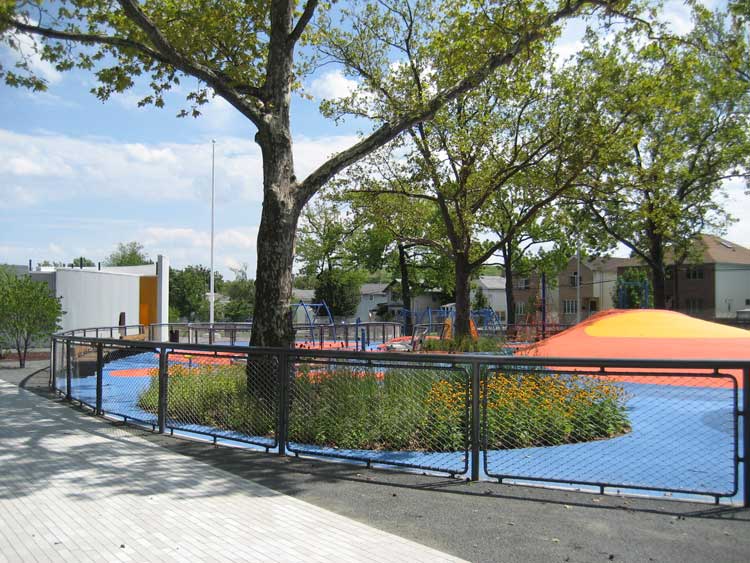 Schmul Park playground features colorful play structures and abundant greenery.